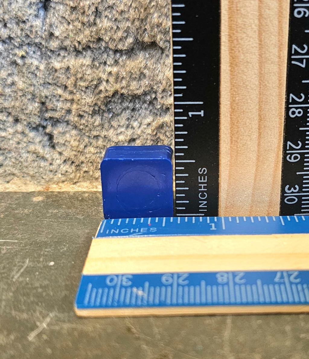 Blue mini square handmade crayon next to a ruler