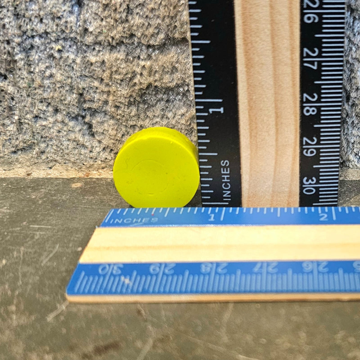 Yellow mini round handmade crayon next to a ruler