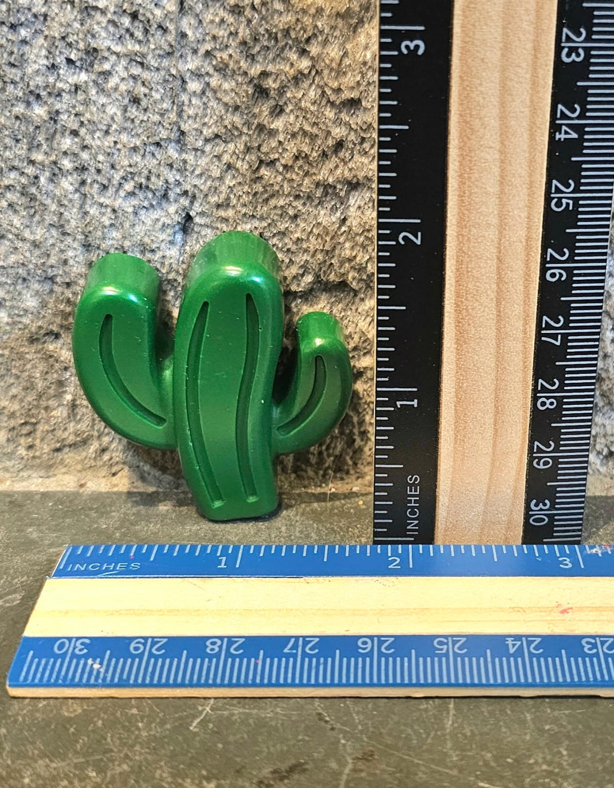 Green cactus shaped handmade crayon next to a ruler