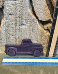 Purple vintage pickup truck shaped handmade crayon next to a ruler