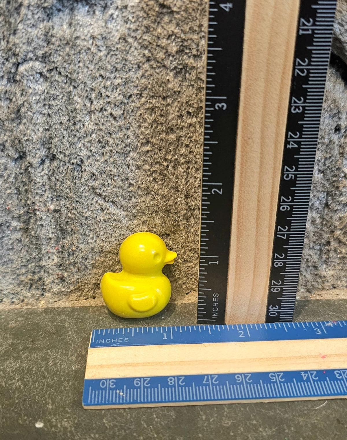 Yellow duck shaped handmade crayon next to a ruler
