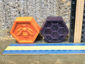 Orange bee and purple honeycomb hexagon crayons next to a ruler